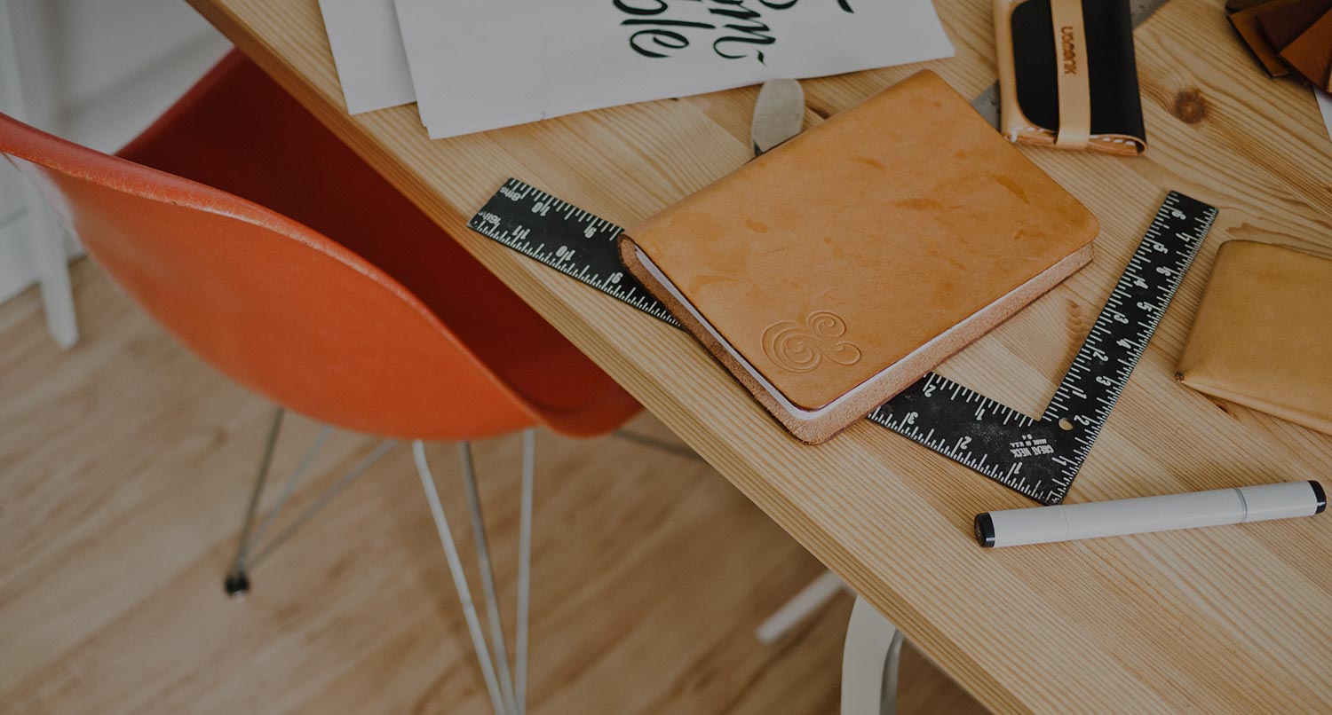 work desk with notepads and laptop