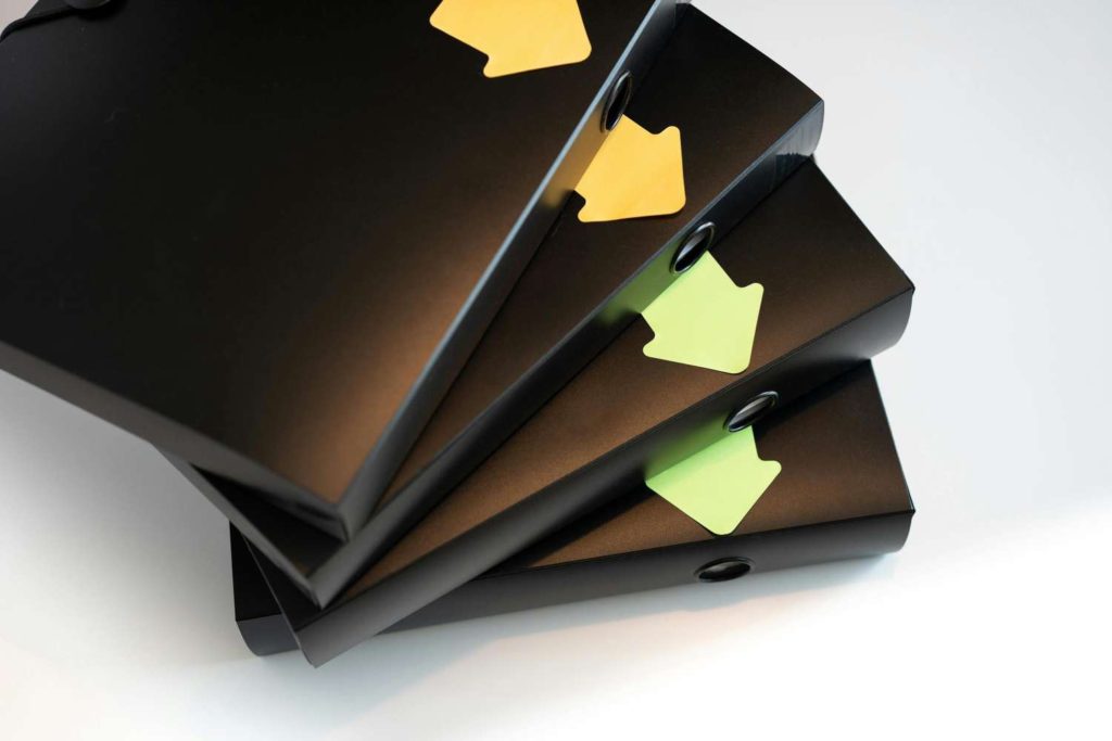 four folders with arrows on them piled up